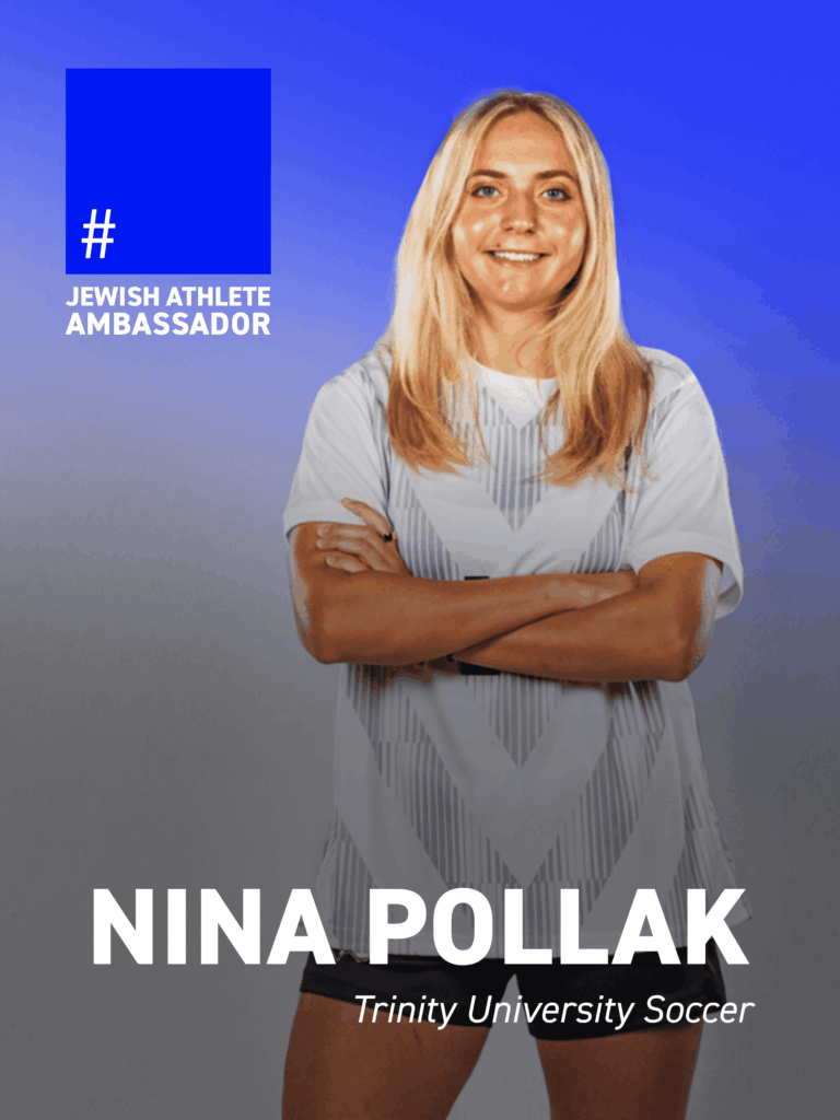 Nina Pollak is shown standing against a clean blue gradient background, wearing a soccer jersey and black shorts with her arms crossed. She smiles confidently at the camera in a composed, studio-style portrait. A blue graphic overlay in the upper left reads “Jewish Athlete Ambassador.” Bold white text at the bottom identifies her as Nina Pollak, followed by “Trinity University Soccer.”