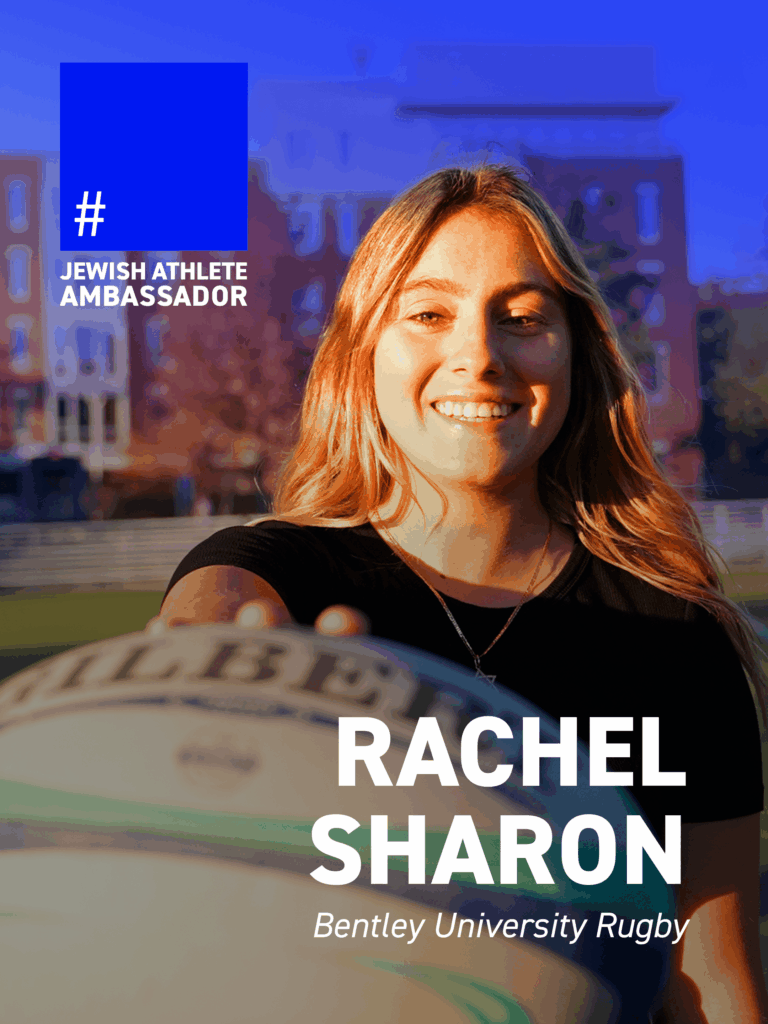 Rachel Sharon, Bentley University rugby player, holding a rugby ball toward the camera outdoors, featured as a Jewish Athlete Ambassador.