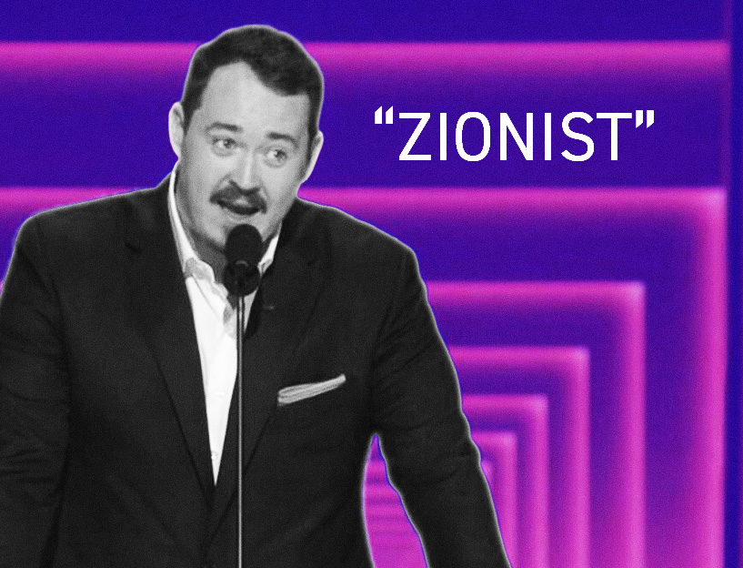 Graphic featuring a black-and-white photo of comedian Shane Gillis speaking at a microphone against a purple neon-style background. Large white text beside him reads “ZIONIST” in quotation marks.