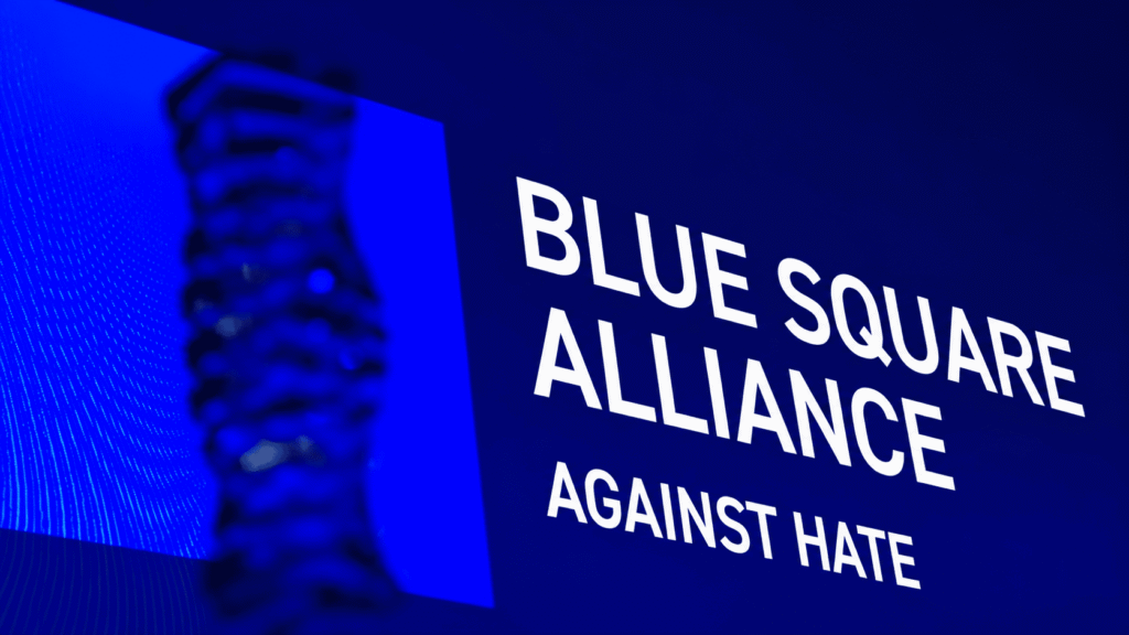 Blue Square Alliance Against Hate logo displayed on a blue-lit event screen.