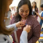 A smiling attendee receives a Blue Square pin at the Stand Up Sunday event at BAPS in Robbinsville.
