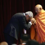 A visitor greets a saffron-robed religious leader at the Stand Up Sunday event at BAPS in Robbinsville.