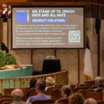 A speaker stands beside a Stand Up Sunday presentation at St. Luke’s Methodist Church in Oklahoma City.