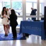 Visitors gather beside a Stand Up Sunday banner and welcome table at St. Nicholas Greek Orthodox Church in New York.